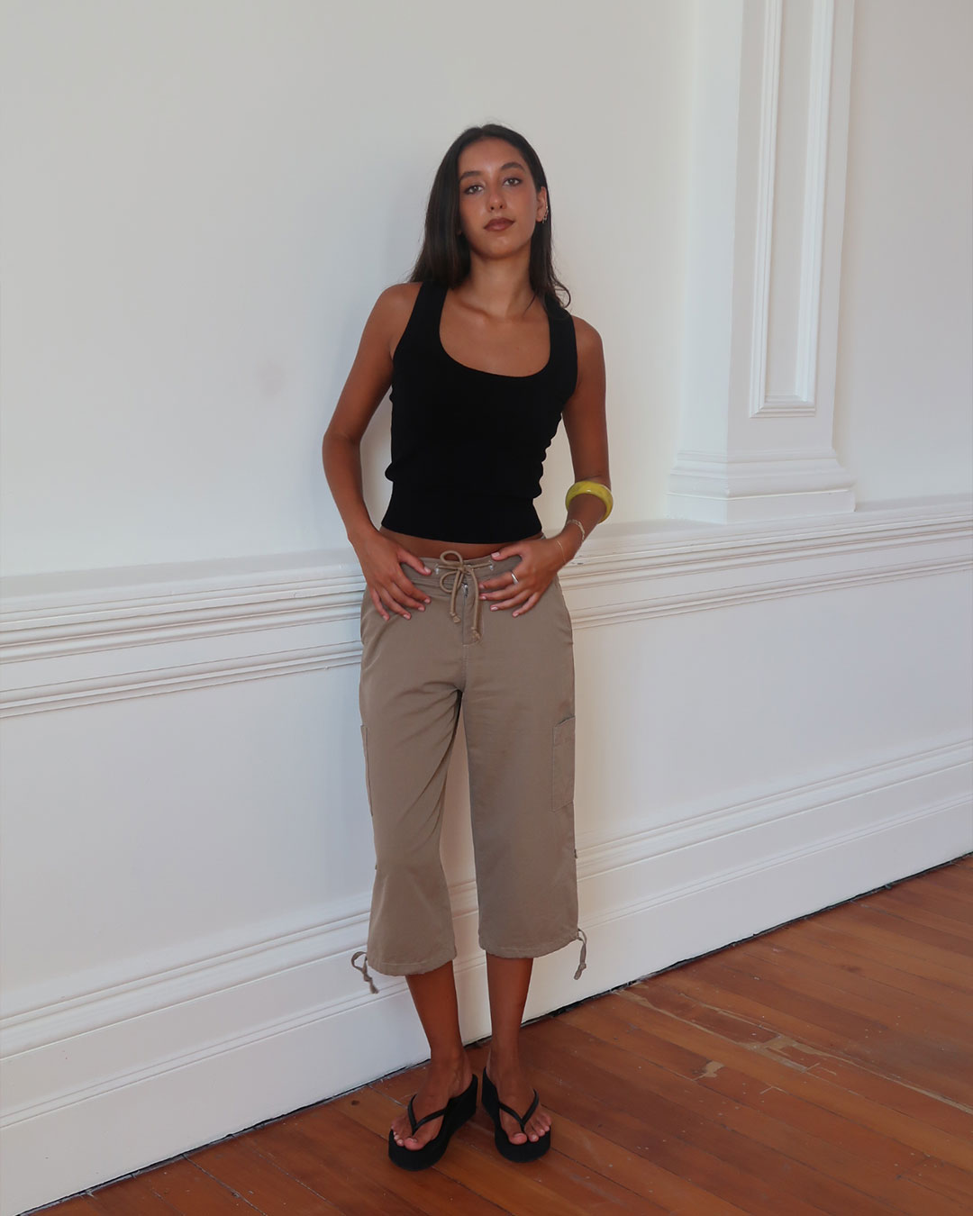 Women's black knit sleeveless top with scoop neck and cinched ribbed waist band