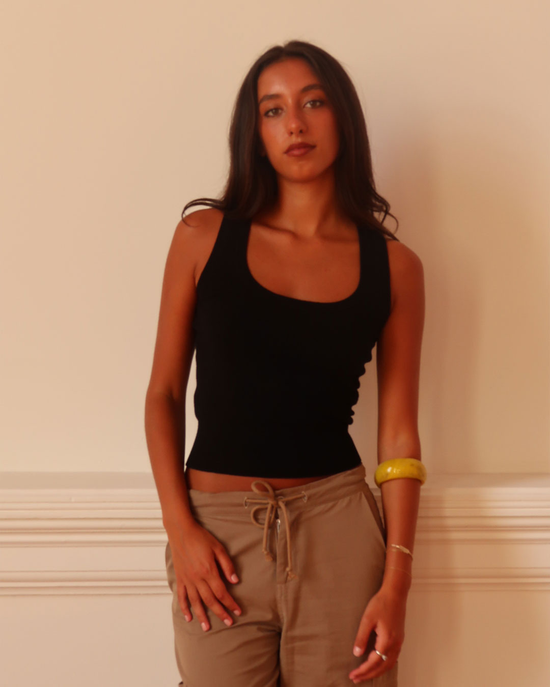 Women's black knit sleeveless top with scoop neck and cinched ribbed waist band