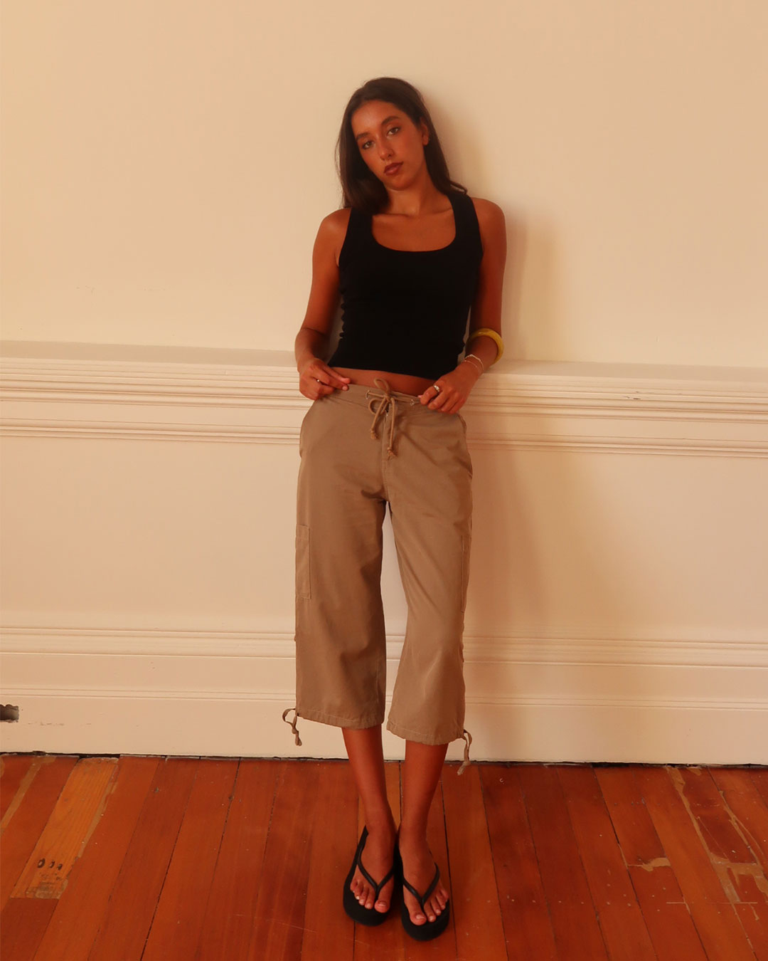 Women's black knit sleeveless top with scoop neck and cinched ribbed waist band