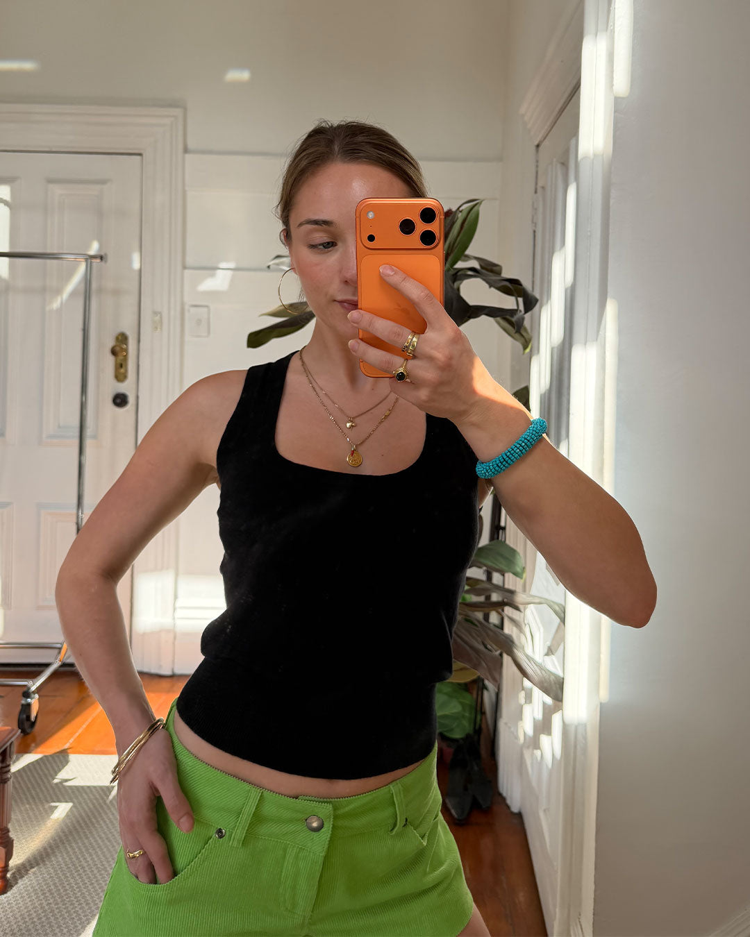 Women's black knit sleeveless top with scoop neck and cinched ribbed wasist band