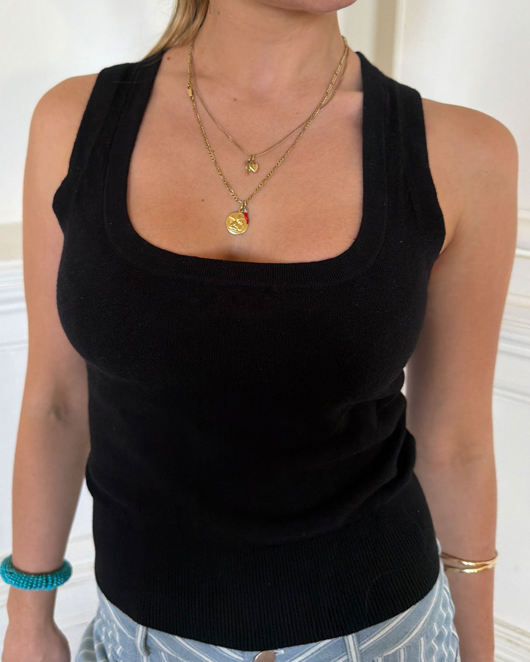 Women's black knit sleeveless top with scoop neck and cinched ribbed wasist band