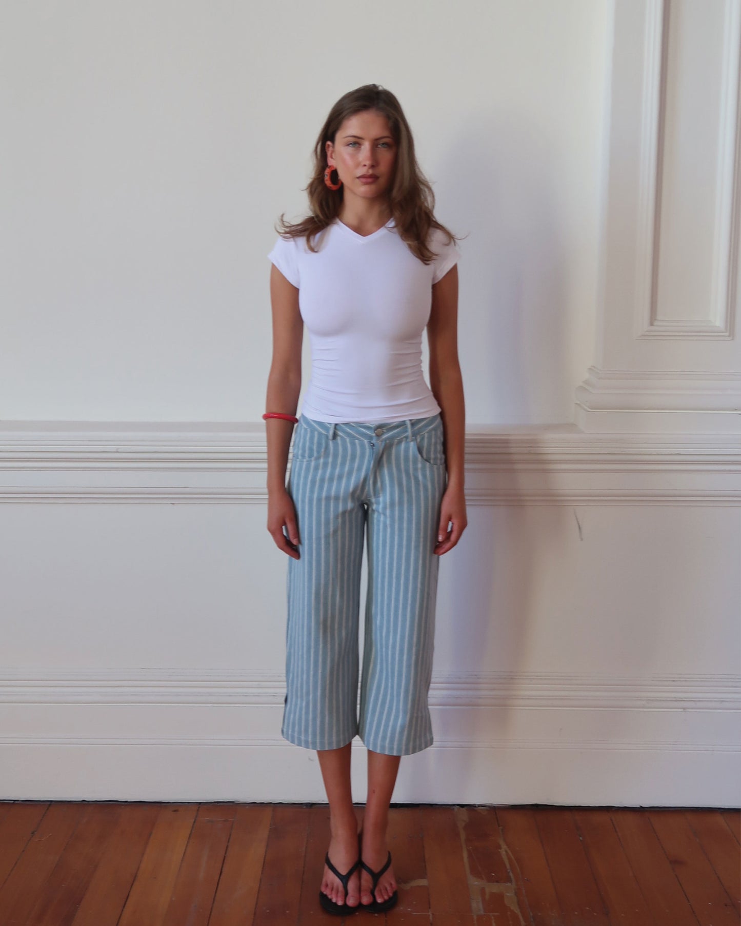 Women's low waisted pant in denim stripe featuring 3/4 length and straight leg fit. 