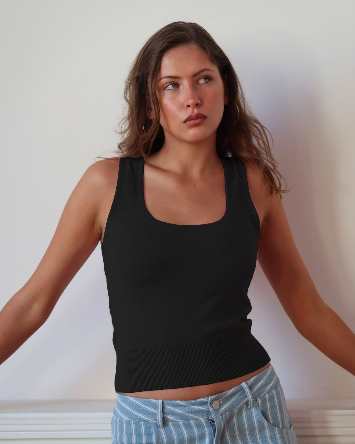 Women's black knit sleeveless top with scoop neck and cinched ribbed waist band